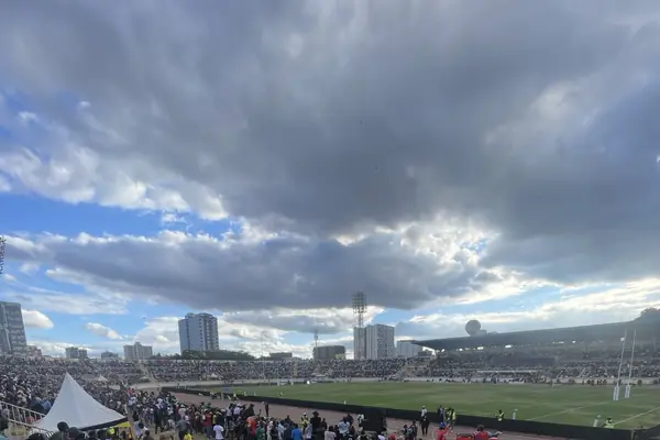 Storm clouds over Nyayo National Stadium in Nairobi, fans gathered at the trackside beside the pitch